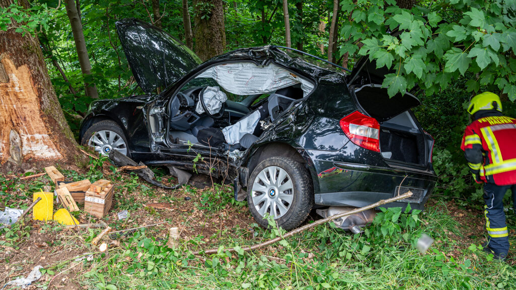 Unfallwrack eines kompakten BMW, der gegen einen Baum geprallt war.