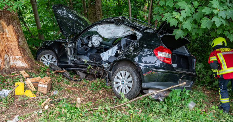 Unfallwrack eines kompakten BMW, der gegen einen Baum geprallt war.